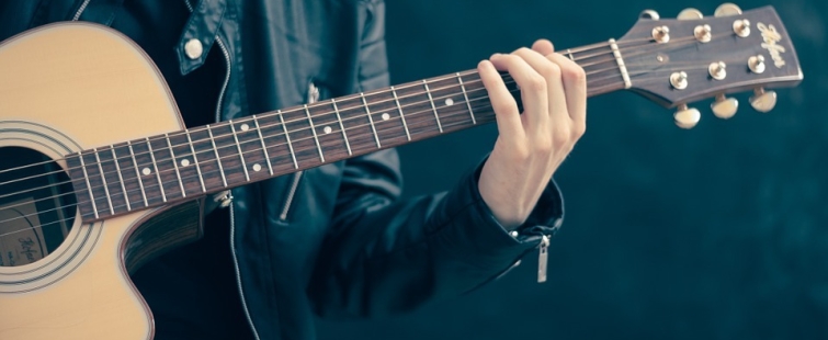 Powiększ obraz: Grafika z osobą trzymającą gitarę